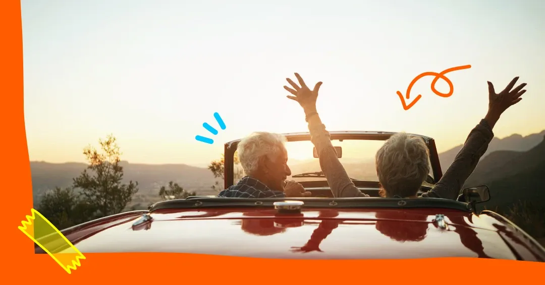 anziani su un'auto cabrio al tramonto